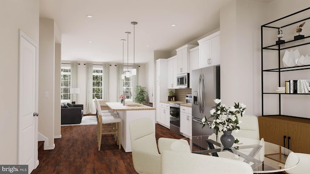 kitchen with dark hardwood / wood-style flooring, a center island with sink, white cabinets, and stainless steel appliances