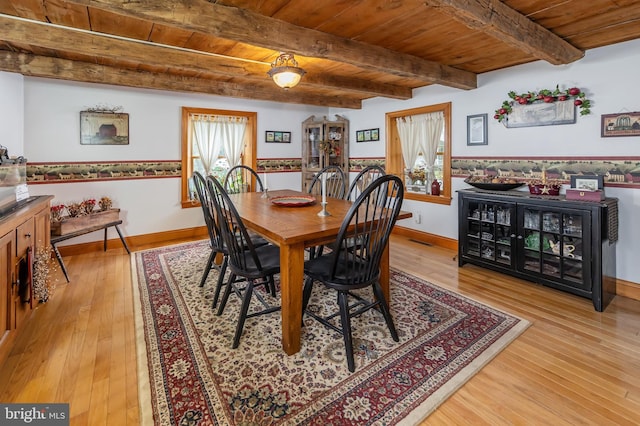 dining room featuring wood ceiling, beam ceiling, and light wood-type flooring