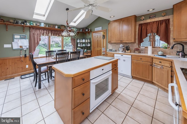 kitchen featuring white appliances, ceiling fan, sink, and light tile floors