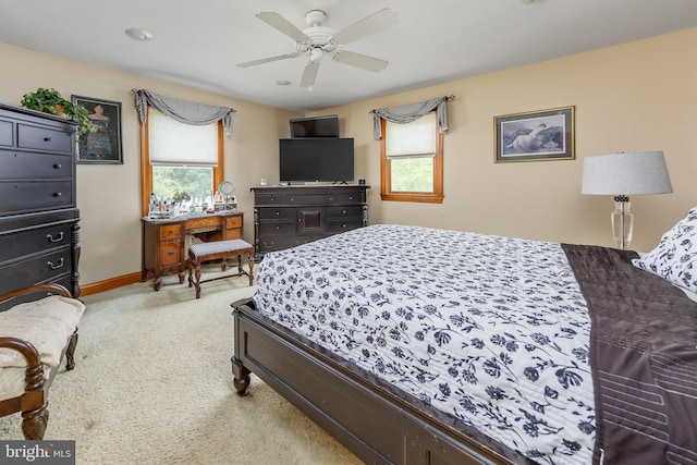 bedroom with light colored carpet, ceiling fan, and multiple windows