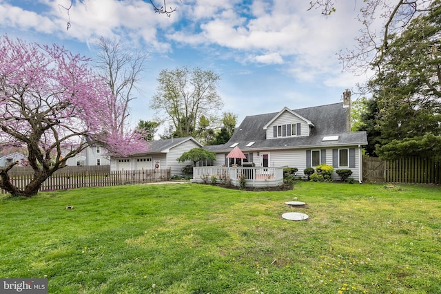 back of property featuring a deck and a yard