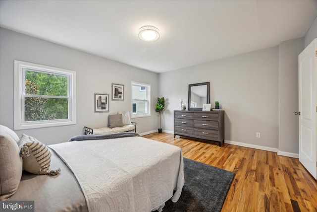 bedroom with light wood-type flooring and multiple windows