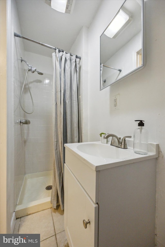 bathroom featuring walk in shower, vanity, and tile patterned floors