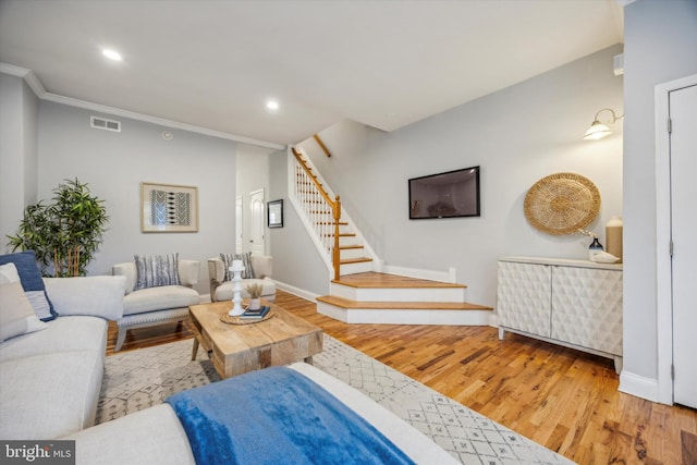 living room featuring wood-type flooring and crown molding