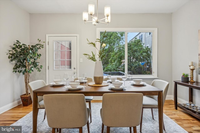 dining space featuring light hardwood / wood-style floors and an inviting chandelier