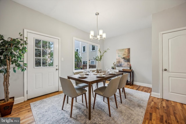 dining area featuring light hardwood / wood-style floors and an inviting chandelier