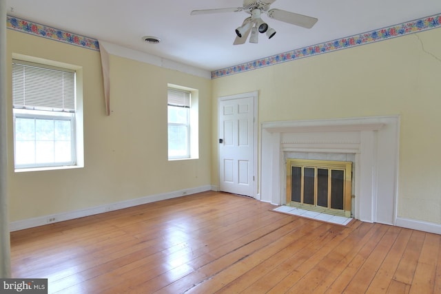 unfurnished living room with plenty of natural light, ceiling fan, and light wood-type flooring