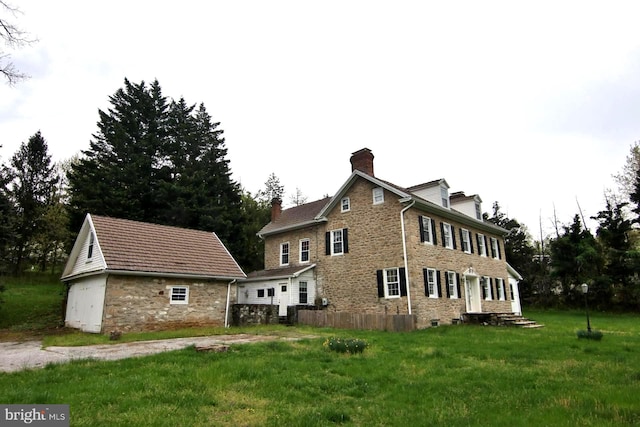 back of property with a lawn and an outdoor structure