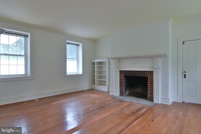 unfurnished living room featuring hardwood / wood-style floors, a fireplace, and a wealth of natural light