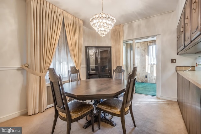 dining room with light carpet and an inviting chandelier