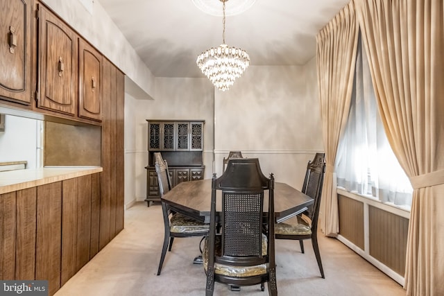 dining room with light colored carpet and a notable chandelier