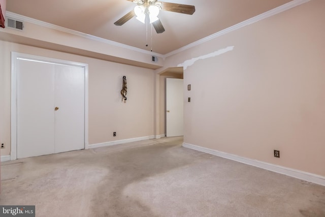 carpeted empty room featuring ceiling fan and crown molding