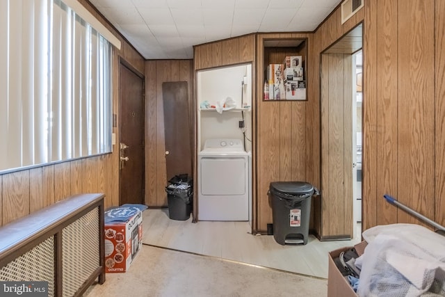 interior space with wood walls, washer / dryer, and light wood-type flooring