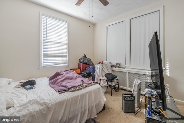 carpeted bedroom featuring radiator heating unit and ceiling fan