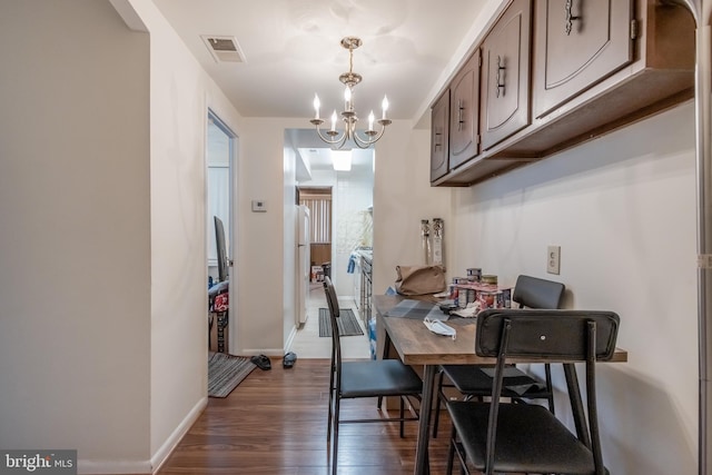 dining room featuring an inviting chandelier and dark hardwood / wood-style flooring