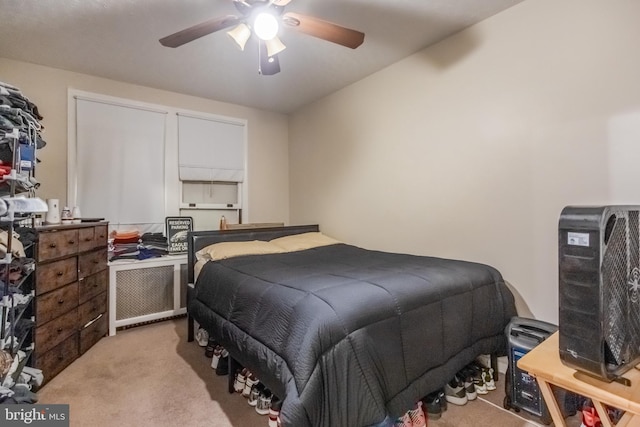 bedroom with ceiling fan, light carpet, and radiator heating unit