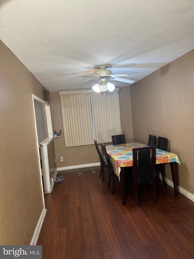 dining room with a textured ceiling, ceiling fan, and dark hardwood / wood-style floors