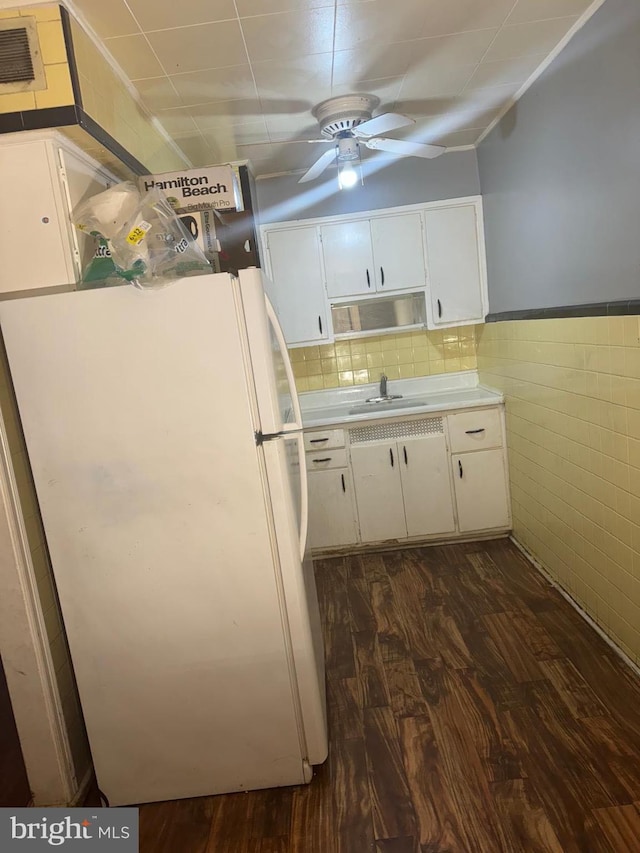 kitchen with white cabinetry, dark hardwood / wood-style flooring, white fridge, sink, and ceiling fan