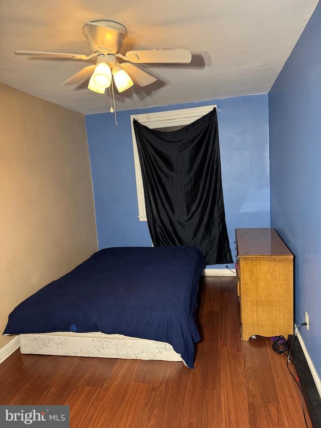 unfurnished bedroom with ceiling fan and dark wood-type flooring