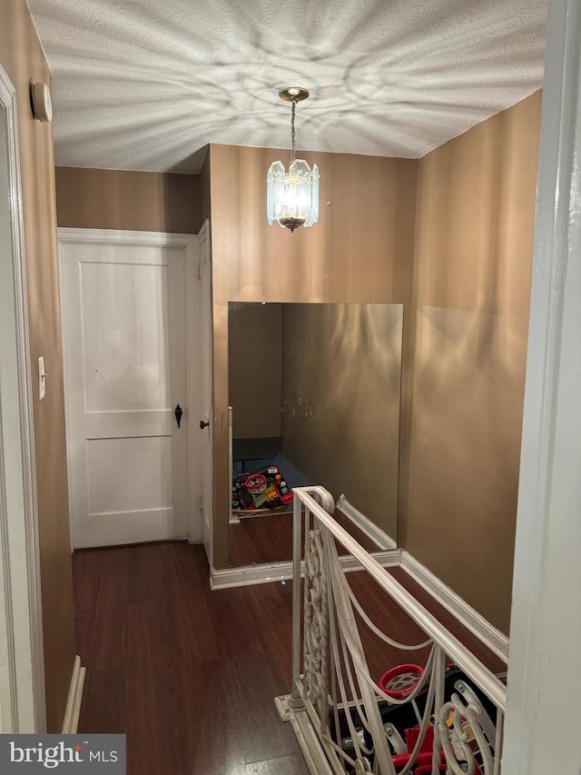 hallway featuring an inviting chandelier and dark hardwood / wood-style flooring