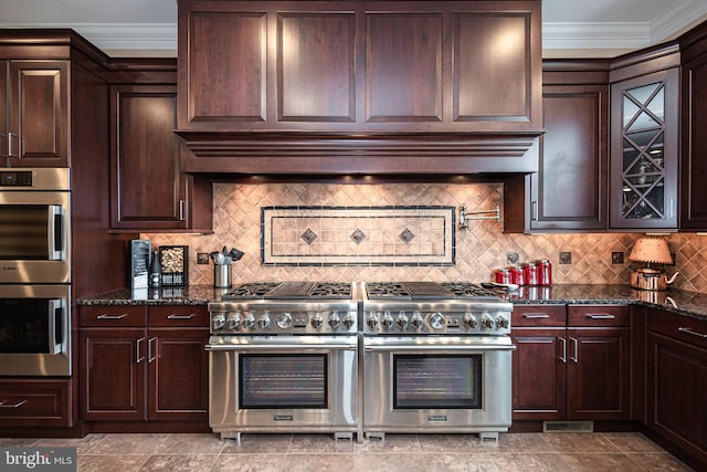 kitchen with visible vents, wall chimney exhaust hood, dark stone countertops, stainless steel appliances, and crown molding