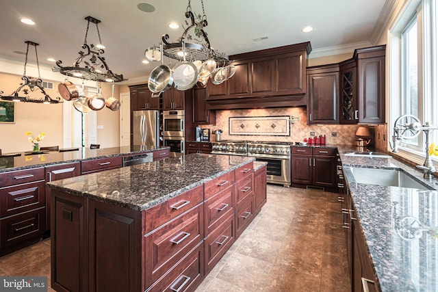 kitchen featuring appliances with stainless steel finishes, backsplash, a sink, and a center island