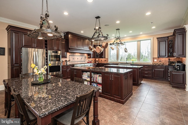 kitchen with a center island, crown molding, decorative backsplash, appliances with stainless steel finishes, and dark brown cabinetry