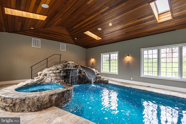 view of swimming pool featuring a skylight and a pool with connected hot tub