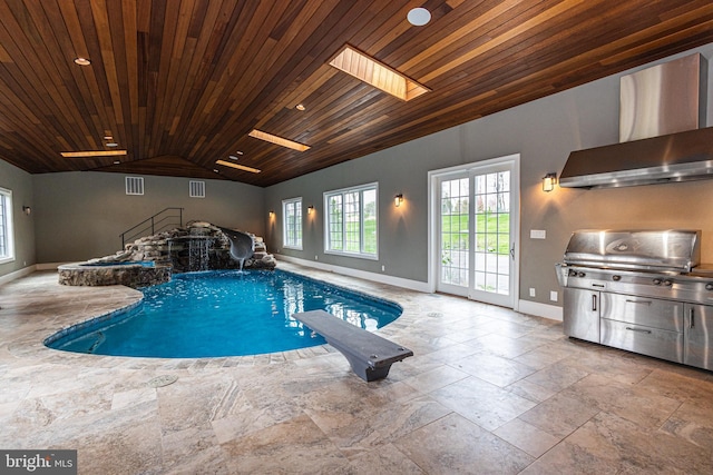 indoor pool featuring a skylight, a diving board, and area for grilling