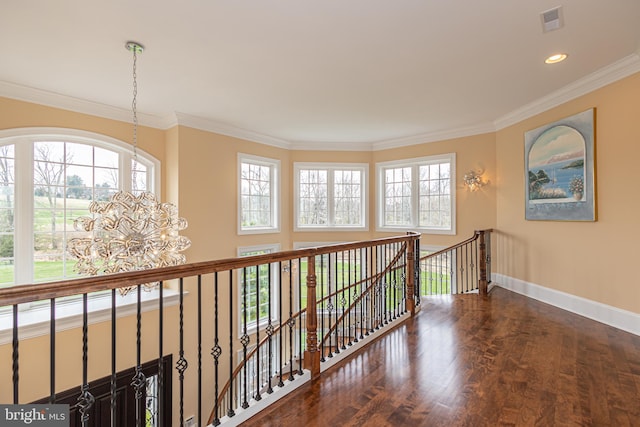 corridor featuring wood finished floors, visible vents, an upstairs landing, baseboards, and crown molding