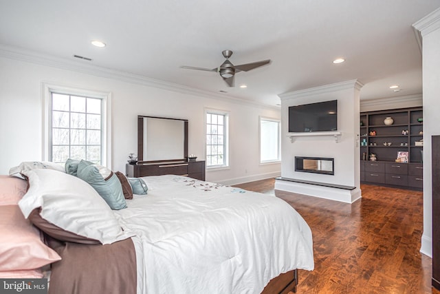 bedroom featuring dark wood-style floors, visible vents, crown molding, and a multi sided fireplace