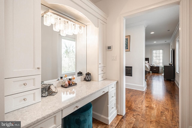 bathroom featuring baseboards, wood finished floors, crown molding, vanity, and recessed lighting