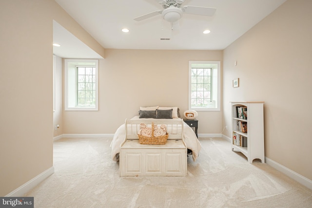 bedroom with recessed lighting, multiple windows, light carpet, and baseboards