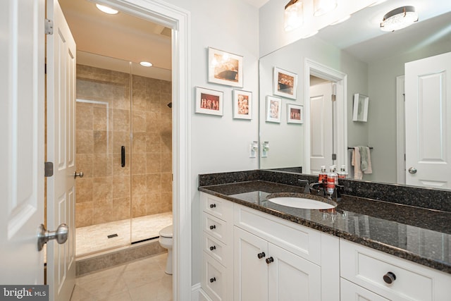 bathroom featuring toilet, recessed lighting, vanity, a shower stall, and tile patterned floors