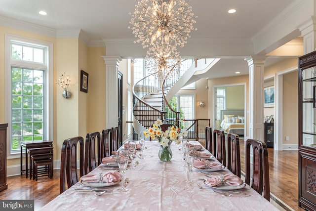 dining space with a healthy amount of sunlight, an inviting chandelier, decorative columns, and crown molding