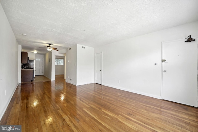 unfurnished living room featuring a textured ceiling, hardwood / wood-style floors, and ceiling fan