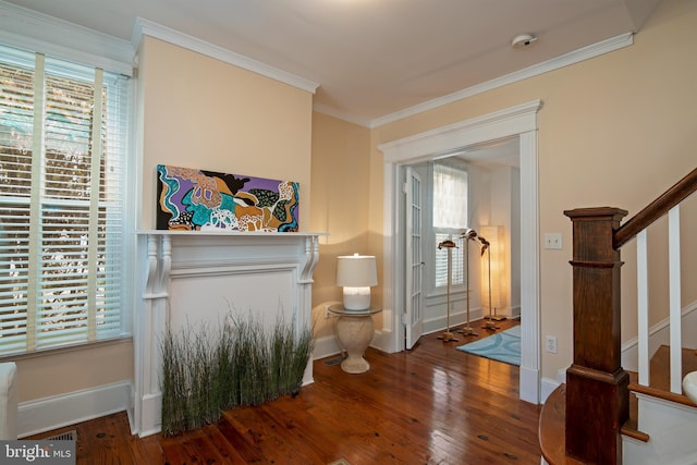 foyer featuring a healthy amount of sunlight, hardwood / wood-style flooring, and crown molding