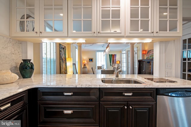 kitchen with sink, white cabinets, stainless steel dishwasher, and light stone countertops