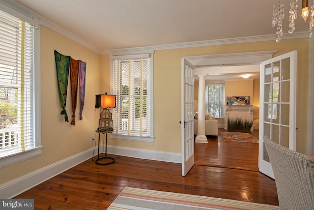 foyer with a wealth of natural light, crown molding, and hardwood / wood-style flooring