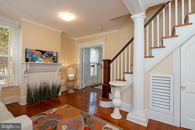 entrance foyer with ornate columns, dark hardwood / wood-style flooring, and ornamental molding