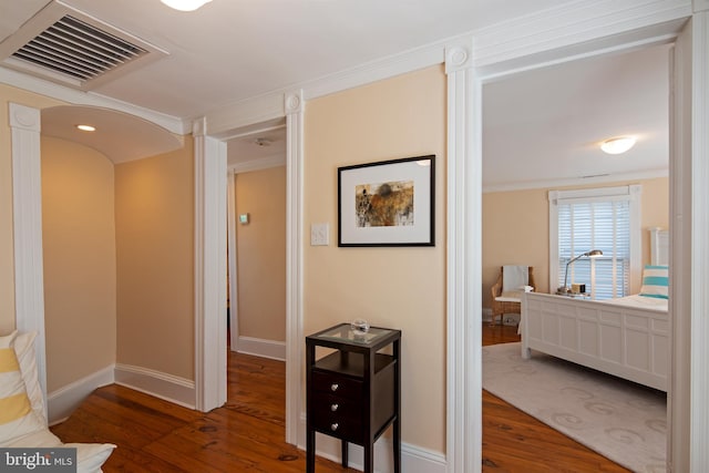 corridor featuring ornamental molding and dark hardwood / wood-style floors