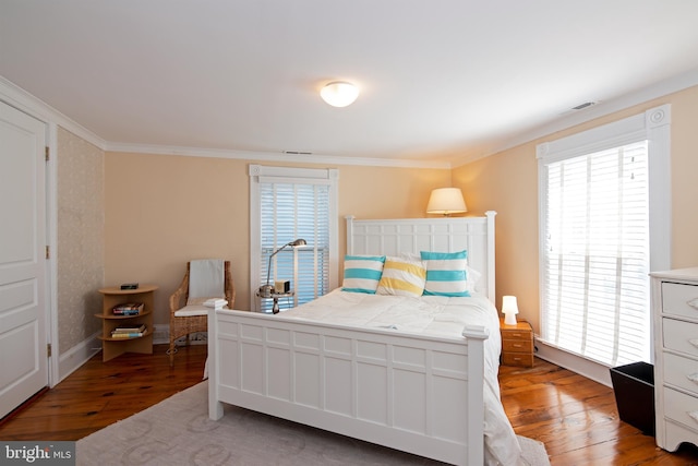 bedroom with ornamental molding, wood-type flooring, and multiple windows