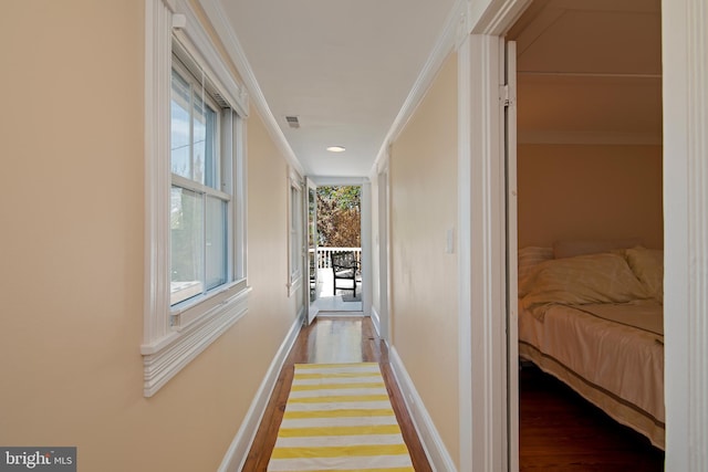 hallway with ornamental molding and hardwood / wood-style floors