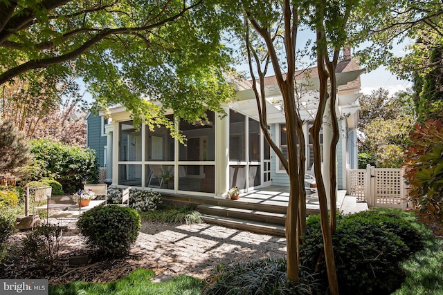 rear view of house featuring a patio area and a sunroom