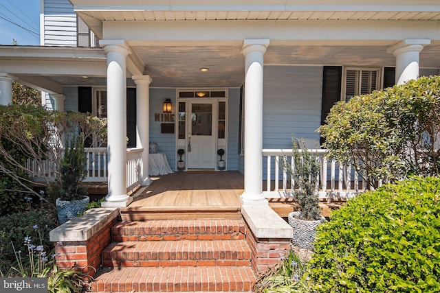 view of exterior entry featuring covered porch