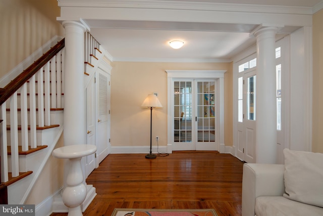 foyer entrance with hardwood / wood-style floors, decorative columns, and ornamental molding