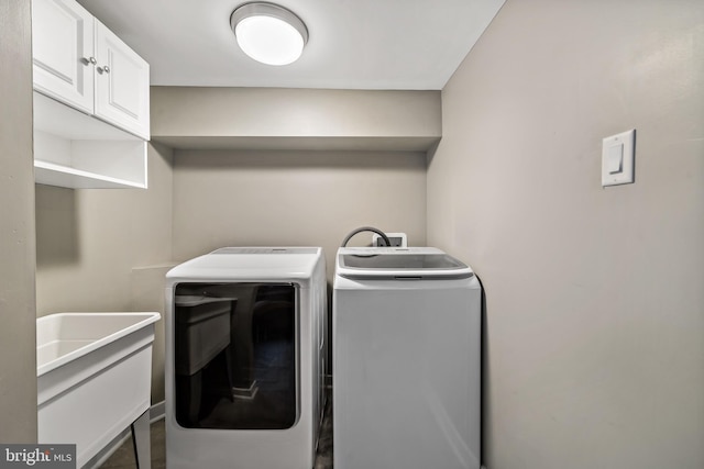 laundry area with sink, washer and dryer, and cabinets