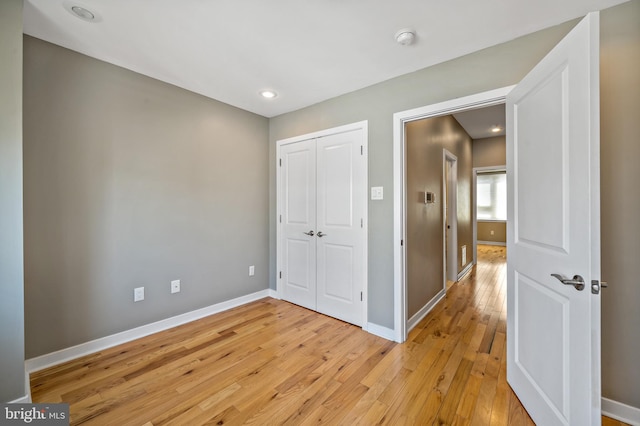 unfurnished bedroom featuring a closet and light hardwood / wood-style flooring