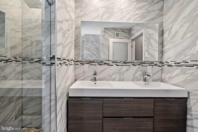 bathroom featuring double vanity and tile walls