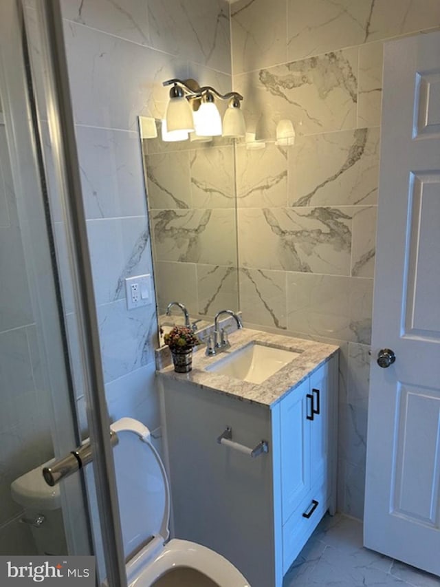 bathroom featuring tile walls, tile flooring, and vanity